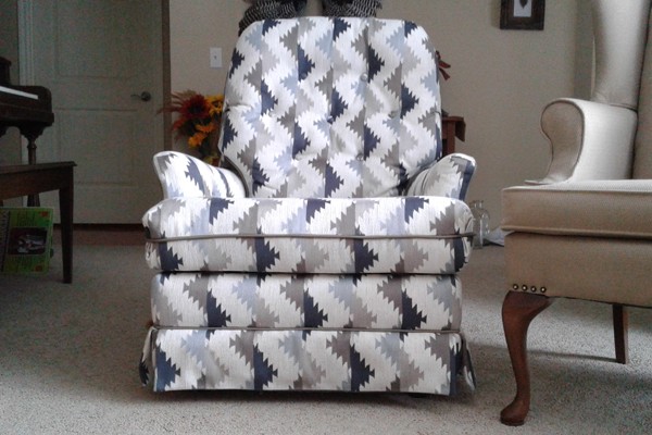 A recliner reupholstered in grey and white geometric fabric
