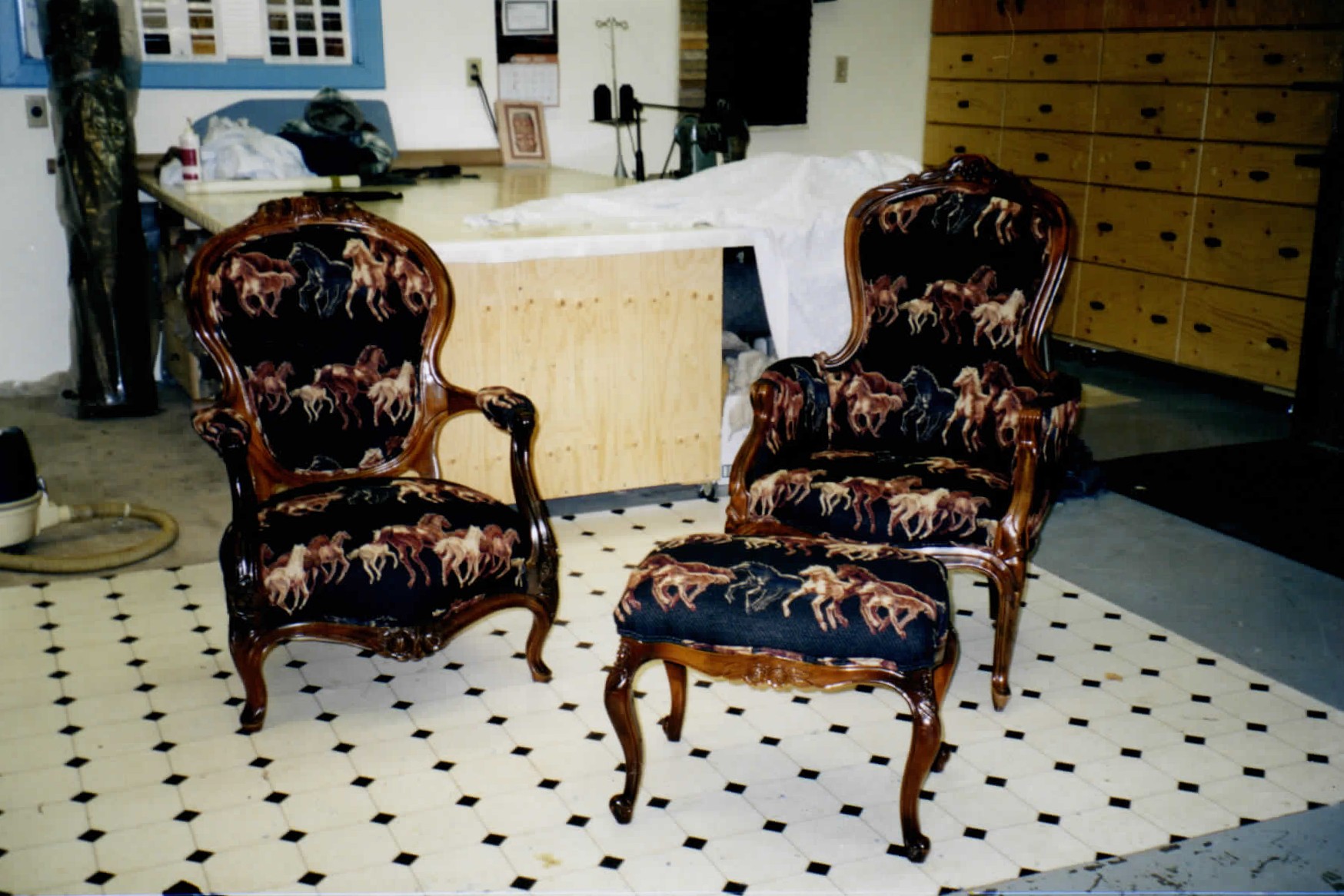 Two armchairs and a matching footstool in dark patterned upholstery