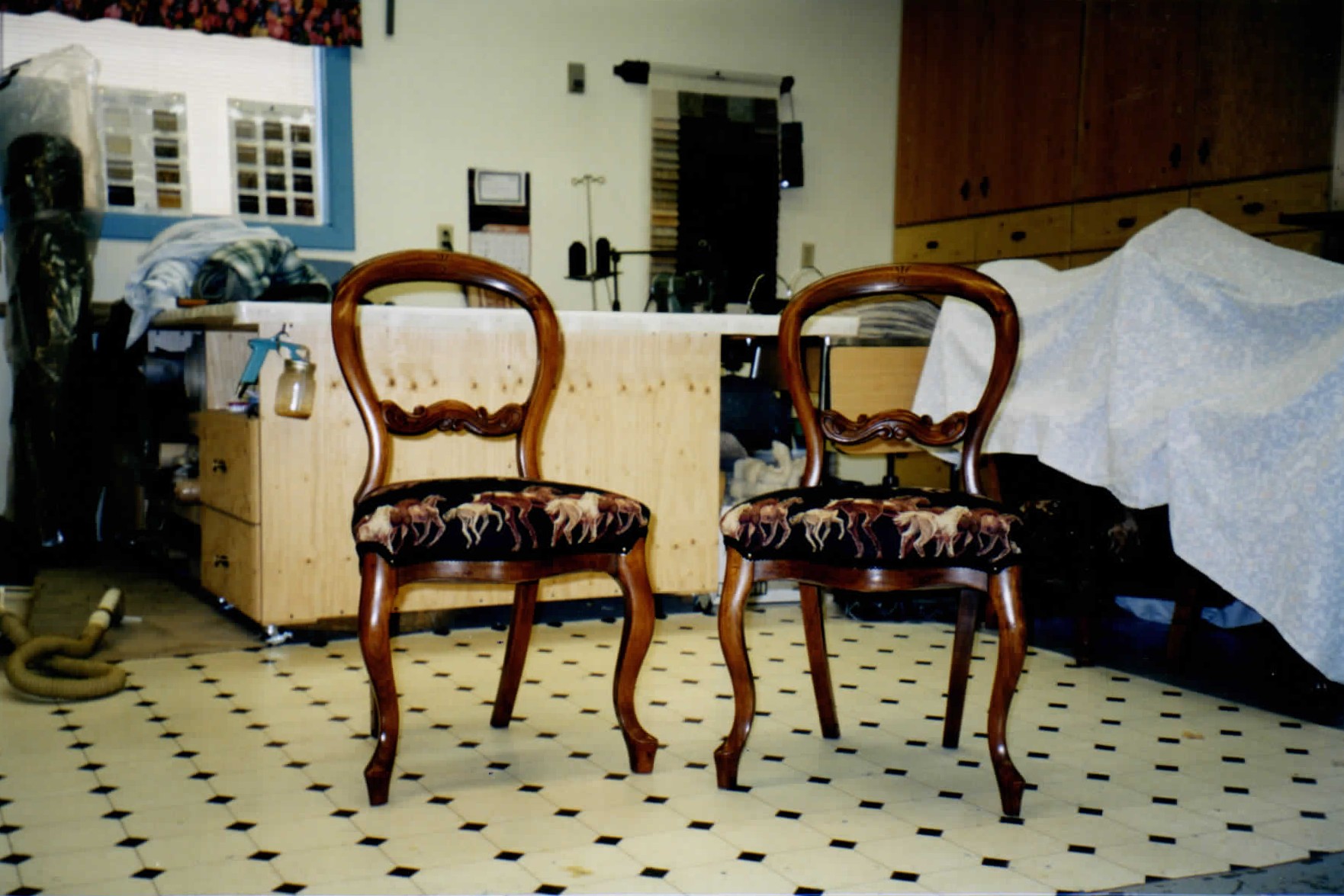 A pair of wood frame dining chairs with patterned upholstered seats