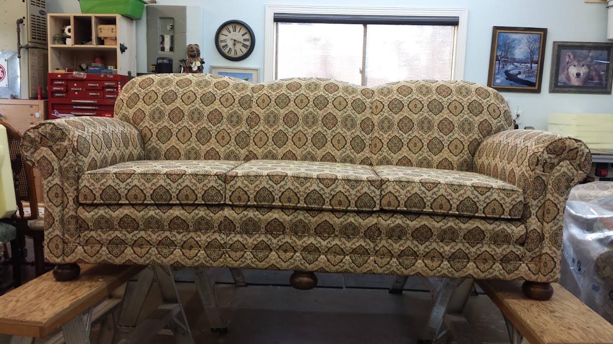 A rolled-arm sofa upholstered in beige medallion-patterned fabric