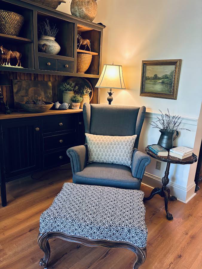 A grey wingback armchair with a patterned cushion and a patterned upholstered footstool